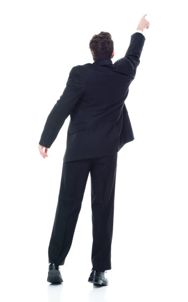 后视图/全长/一个20-29岁的成年美丽的高加索年轻女性/女经理/商人/商人站在白色背景穿着西装和触摸/显示伸手图片下载