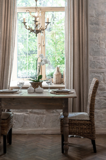 垂直照片舒适的房子与木制室内设计。两个人的节日餐桌设置与别致的葡萄酒杯，盘子，餐具和兰花在花盆图片下载