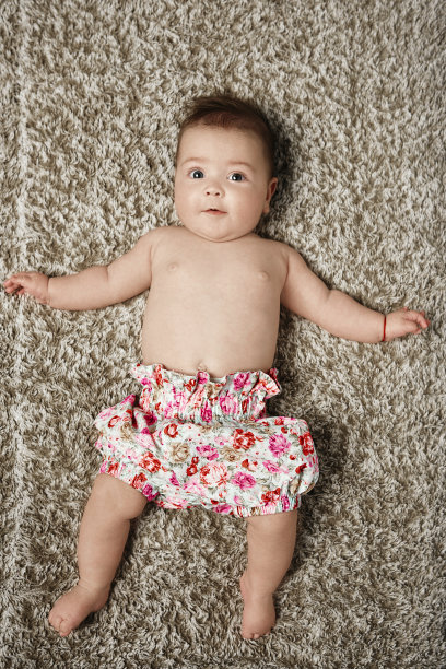 最可爱的小女孩躺在地毯上图片下载