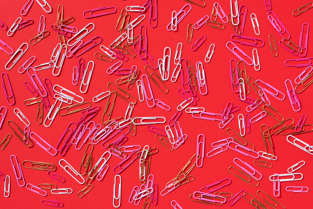 彩色回形针在粉彩红色背景。俯视图，平放。回到学校的概念。大学，学院教育，办公室工作图片下载