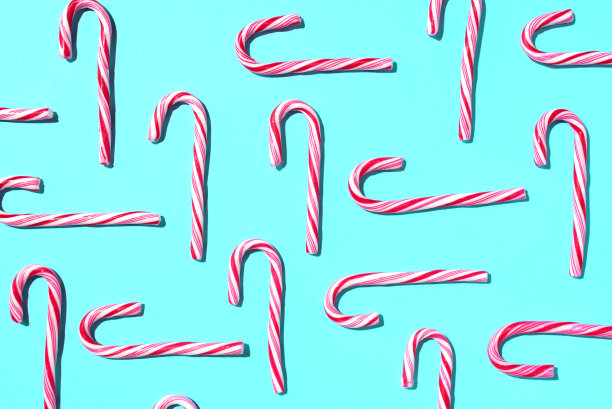 蓝色背景上的圣诞糖果手杖图案。前视图。平的。创造性的最小概念。圣诞和新年的贺卡。艺术成分。图片下载
