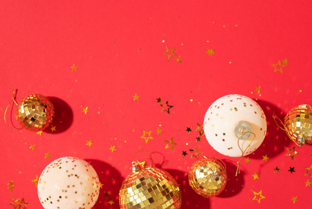 圣诞节的白色和金色装饰，镜子迪斯科球，星星闪烁在红色的背景。平躺，俯视图。最小的新年派对概念。圣诞贺卡与副本空间图片下载