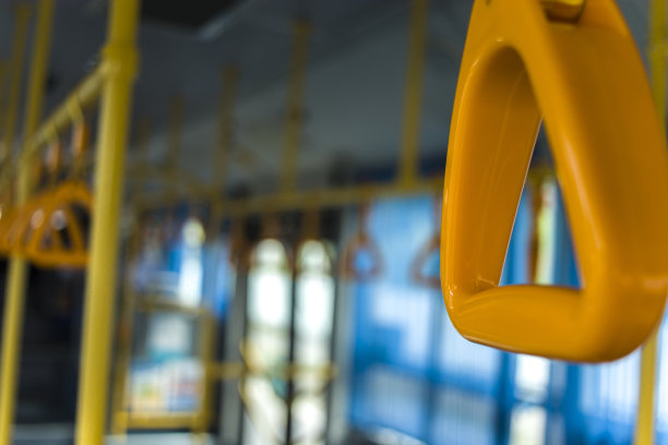 在现代公共汽车上，为站着的乘客准备的黄色拉手。郊区和城市交通图片下载