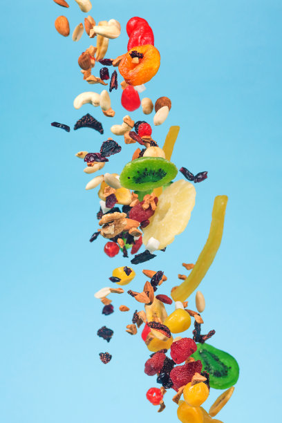 干果、蜜饯和坚果在蓝色背景上飞舞。健康和营养食物的库存照片。图片下载