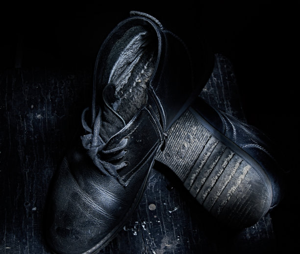 一双老人的旧鞋。俯视图，暗照片。图片下载