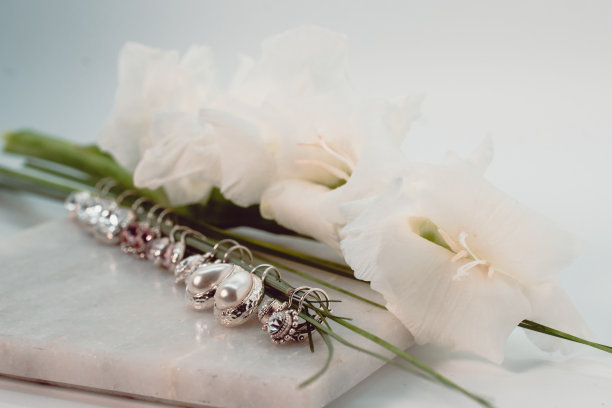 特写耳环和白玫瑰在白色的背景图片下载