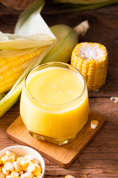 新鲜甜玉米汁(玉米奶)和玉米在木材背景图片下载