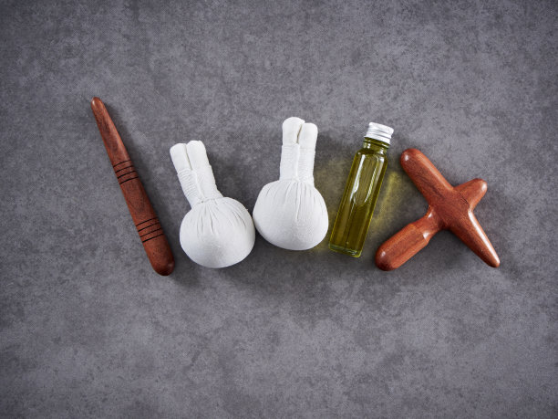 美丽的spa组成与瓜沙木，草药敷球，椰子油，瓜沙泰国草药油在灰色大理石背景。放松按摩。图片下载