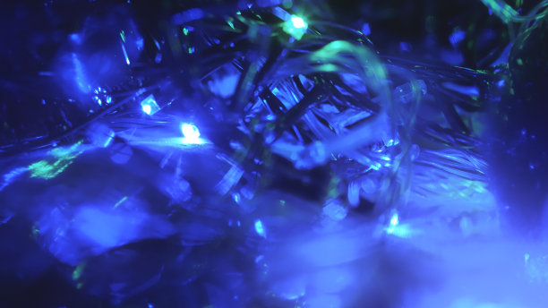 圣诞五彩缤纷，新年虚掩霓虹彩灯。模糊的照片背景与闪烁的灯从纠结的花环。装饰用鲜艳的霓虹蓝绿闪烁的灯光图片下载