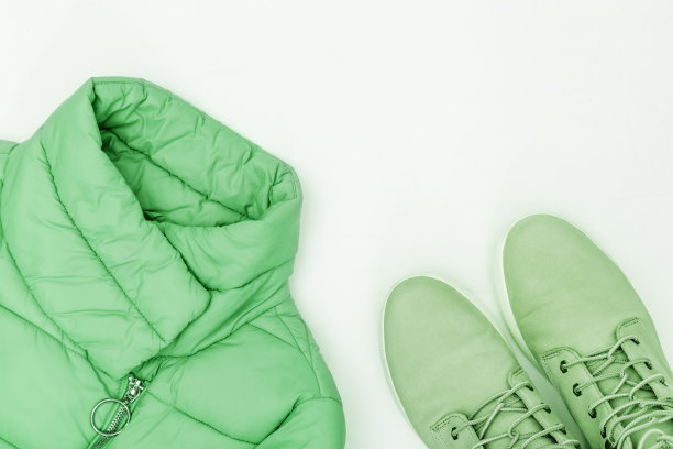 明亮的时尚服装趋势颜色在白色的背景和复制空间。暖和的羽绒服和舒适的靴子。平躺着暖和的妇女衣服。前视图。图片下载