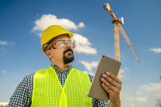 建筑师或工程师在建筑起重机前举着牌匾图片下载