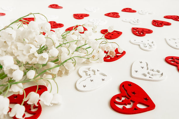 淡色背景上的铃兰。背景上是心的剪影。一束春天的花。有选择性的重点。图片下载