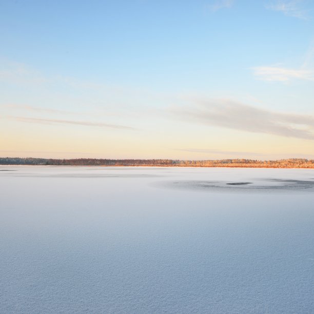 在晴朗的冬日里，湖面上覆盖着一层新雪图片下载
