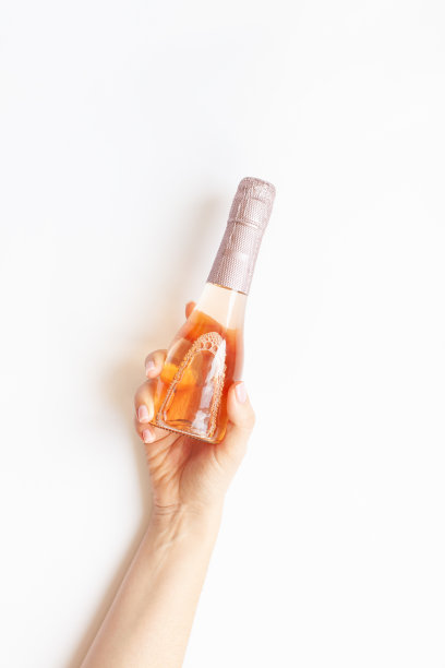 女人手里拿着一瓶玫瑰香槟酒图片下载