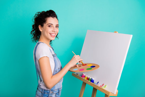 侧面肖像漂亮迷人的创意活泼的波浪发女孩穿着随意在手中水彩画新的图片孤立在明亮生动的亮绿色绿松石背景图片下载