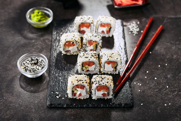 东京三文鱼寿司配米饭，奶油芝士，西红柿，黄瓜，芝麻和紫菜。微距拍摄的日本食物浦卷与熏鱼和新鲜蔬菜图片下载