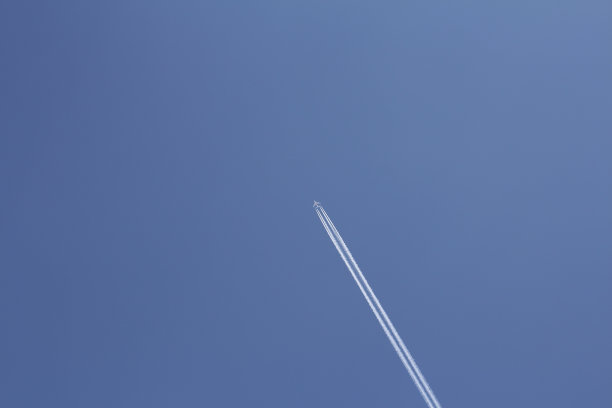 一个大的白色飞机的垂直照片。一架飞机飞过天空。图片下载