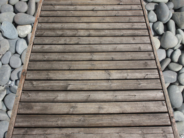 铺在鹅卵石上的木栈道图片下载