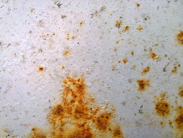 一辆旧汽车的金属片腐蚀。路面生锈，背景和路面盐损坏的纹理。冬季保护、自动涂装。专业的油漆工作。提供高质量的修复部件。图片下载