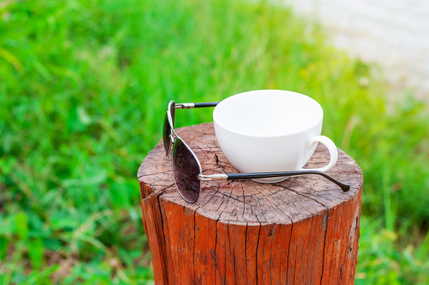 一杯咖啡，一副太阳眼镜放在木头上图片下载