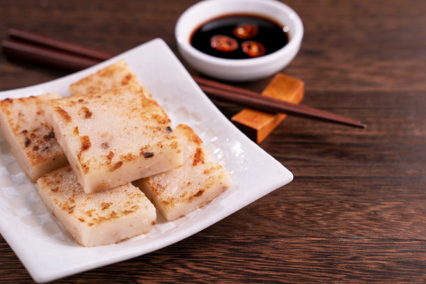 美味的萝卜糕，中国传统的地方菜萝卜糕在餐厅配酱油和筷子。图片下载