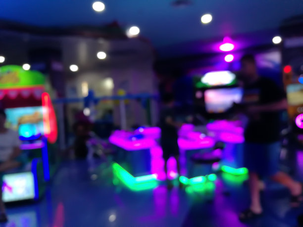 百货商店里小孩子玩游戏的模糊地方。操场上五颜六色的霓虹灯和散焦灯图片下载