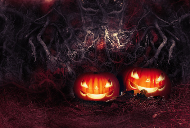万圣节秋天的节日卡片与两个邪恶的微笑发光的杰克南瓜在可怕的可怕的背景上纠结的树根无法通过的墙壁在可怕的黑暗血腥的颜色图片下载