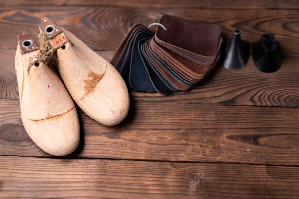 皮鞋和木鞋的皮革样品在深色的木桌上。图片下载