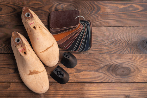 皮鞋和木鞋的皮革样品在深色的木桌上。图片下载