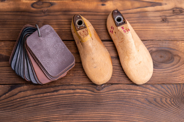 皮鞋和木鞋的皮革样品在深色的木桌上。图片下载