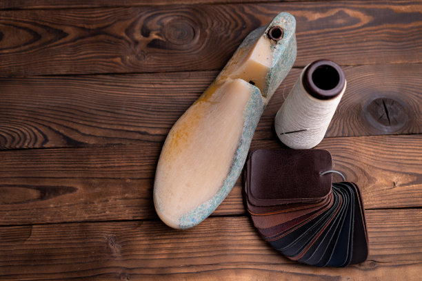 皮鞋和木鞋的皮革样品在深色的木桌上。图片下载