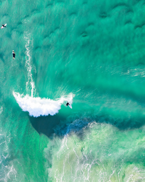 冲浪者乘天线冲浪。一个冲浪者在日出时在黄金海岸冲浪的壮观镜头。图片下载