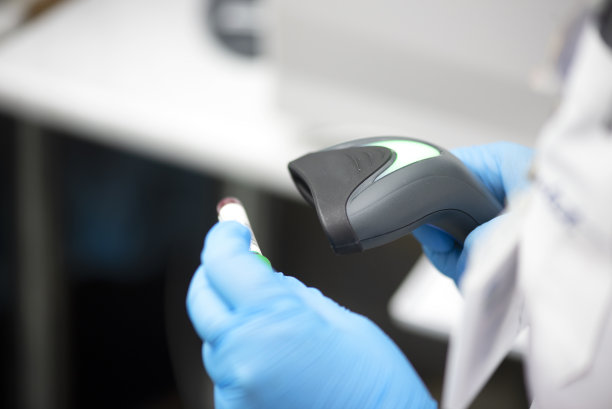 条形码扫描仪和试管在后台监控全血计数分析仪。图片下载