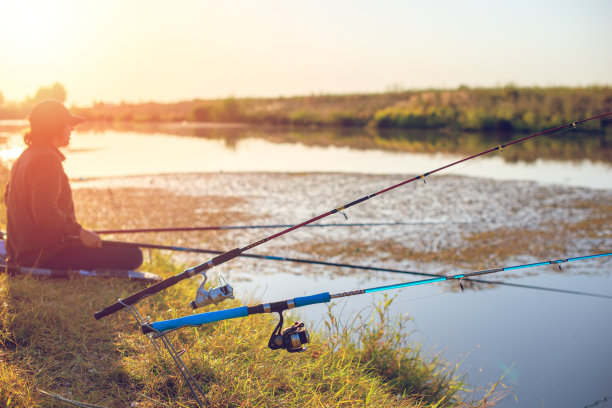 日落时分，池塘上垂钓的女人的剪影图片下载