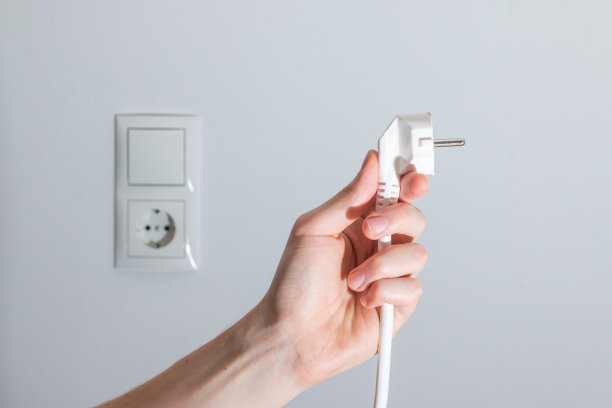 能源概念:插头，准备连接。模糊背景中的白色电缆和插头插座图片下载