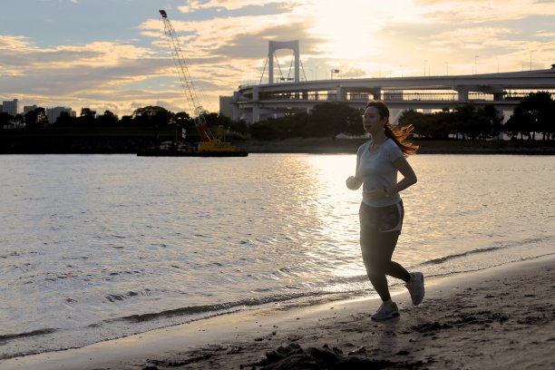 年轻漂亮的女人在沙滩上跑步图片下载