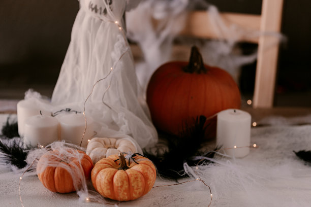 诡异的万圣节装饰有不同的南瓜，灯，蜘蛛。万圣节装饰桌子。图片下载