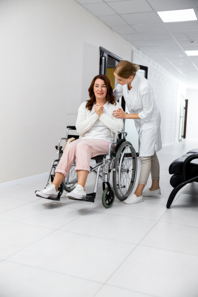年轻的医生与妇女在医院走廊上的轮椅股票照片图片下载
