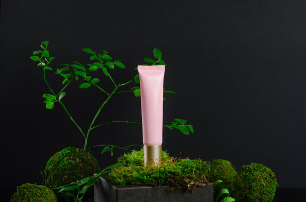 化妆品洗液管和绿色植物模型侧视图。环保美容产品，有机保湿面霜旗帜概念。粉红色容器和可可玉组成。护肤品、化妆品配件图片下载