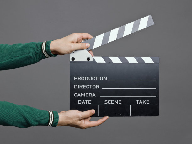 一个拿着电影拍板的男人，在摄影棚拍摄图片下载