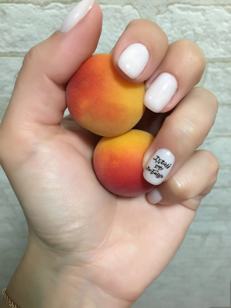 一个女人手里拿着两个美味的杏子。图片下载