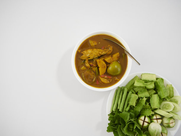 泰国菜。由多种香料制成的风味浓郁的南咖喱，配上新鲜蔬菜放在餐桌上图片下载