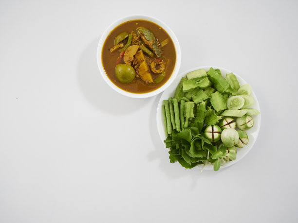 泰国菜。由多种香料制成的风味浓郁的南咖喱，配上新鲜蔬菜放在餐桌上图片下载