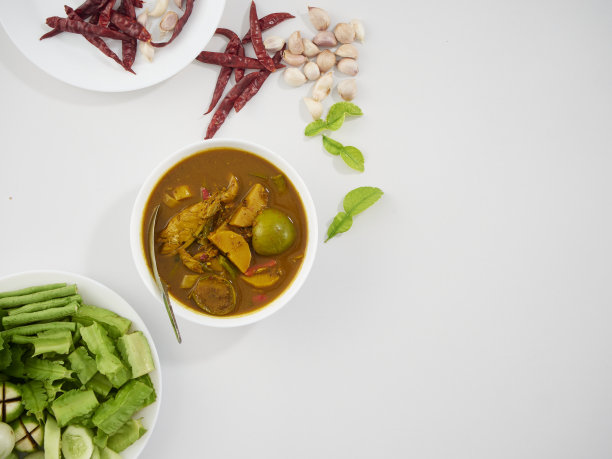 泰国菜。由多种香料制成的风味浓郁的南咖喱，配上新鲜蔬菜放在餐桌上图片下载