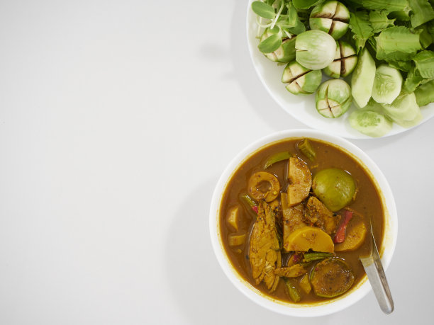 泰国菜。由多种香料制成的风味浓郁的南咖喱，配上新鲜蔬菜放在餐桌上图片下载