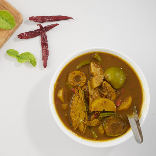泰国菜。由多种香料制成的风味浓郁的南咖喱，配上新鲜蔬菜放在餐桌上图片下载