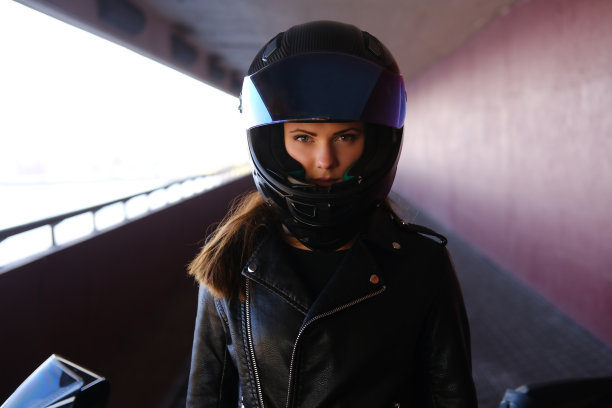 迷人而严肃的女人正站在她的摩托车旁图片下载