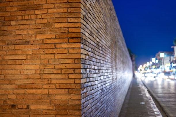 在泰国清迈北部的Tha Phae门墙后，灯光在街道上留下痕迹，清迈古城，古城墙和护城河。图片下载