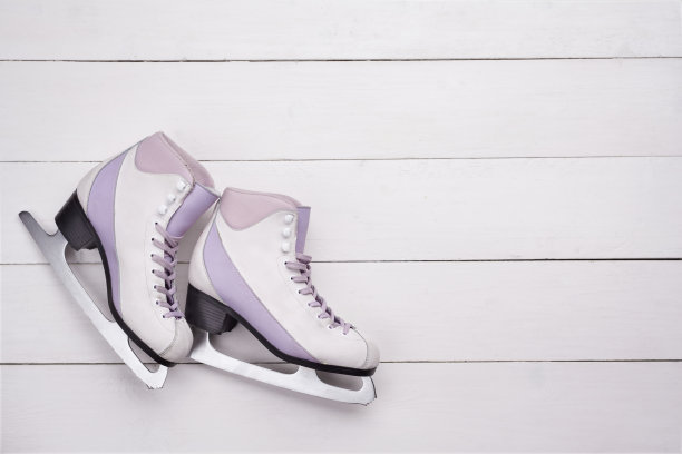 特写照片的专业滑冰鞋躺在一个白色的木制背景图片下载