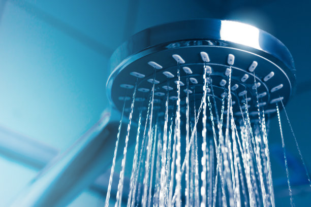一个现代淋浴喷头的特写水，蓝色调的照片。图片下载